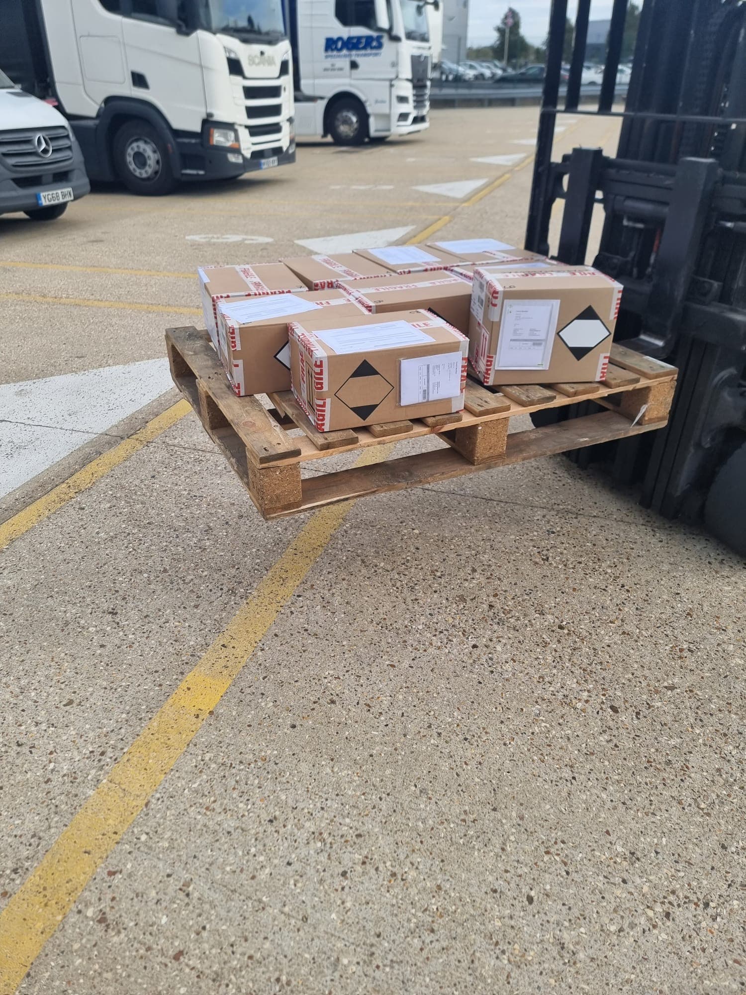 Pallet of boxed goods on a forklift in a haulage yard