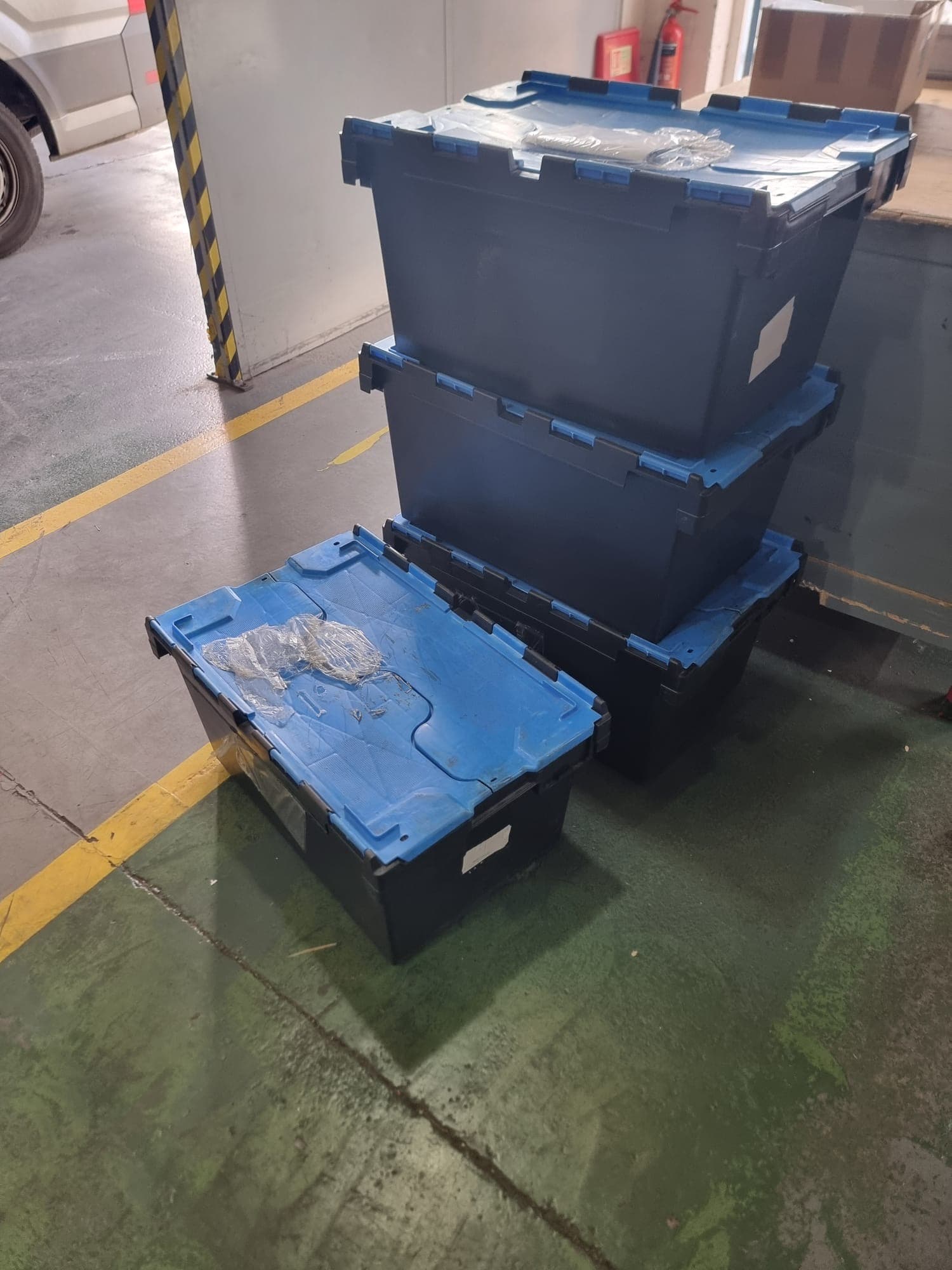 Blue-lidded totes staged for collection